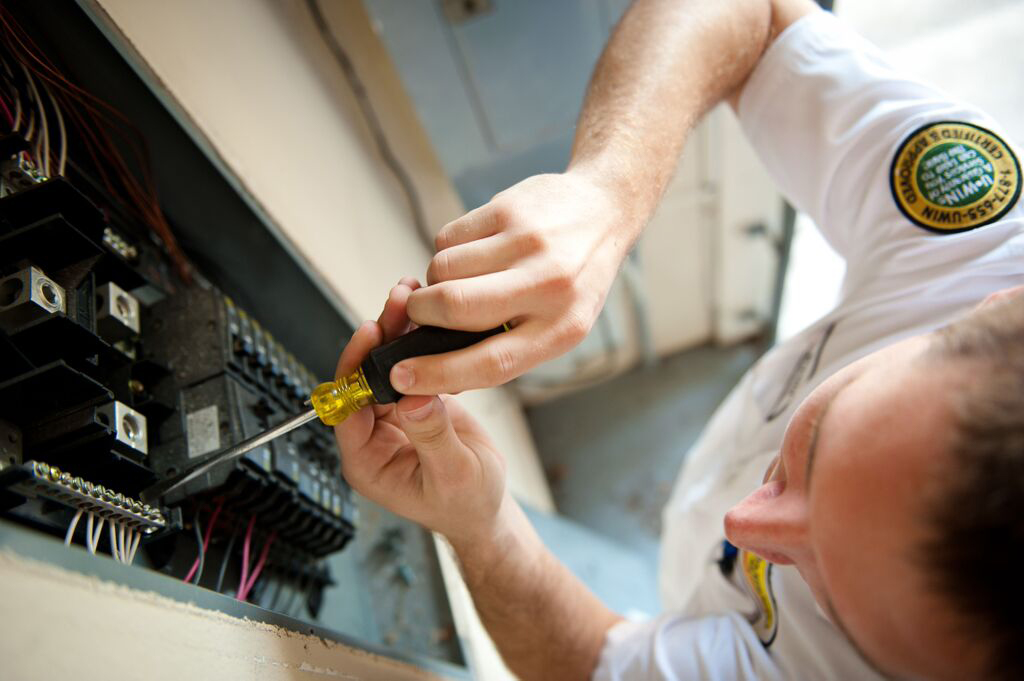 A Mister Sparky Electrician Tulsa technician fixes an electrical main panel in Tulsa, OK.